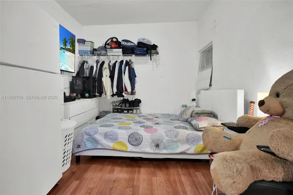 a view of a bedroom with bed and wooden floor