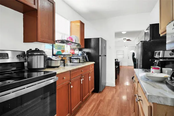 a kitchen with stainless steel appliances kitchen island granite countertop a sink stove and refrigerator