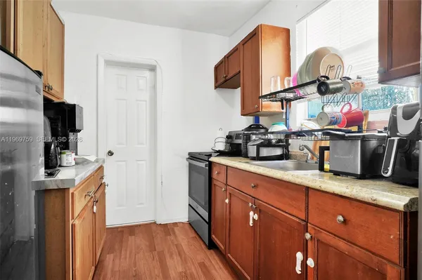 a kitchen with stainless steel appliances granite countertop a sink and wooden cabinets