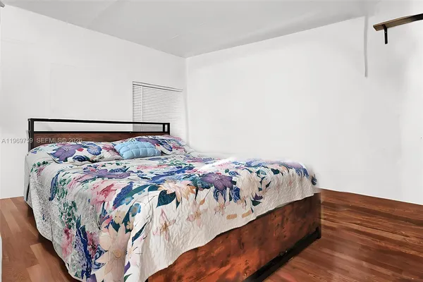 a bed with a white comforter and pillows