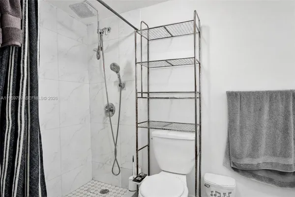 a bathroom with a shower toilet and sink