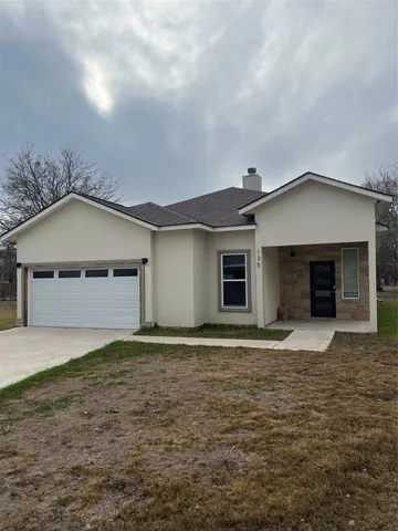 a front view of a house with yard and trees