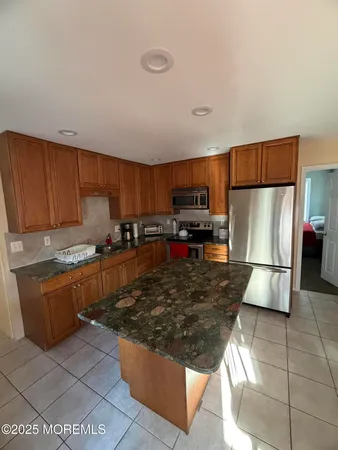 a kitchen with stainless steel appliances granite countertop a refrigerator stove top oven a sink and dishwasher