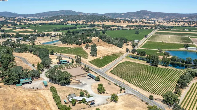 an aerial view of residential houses with outdoor space and trees
