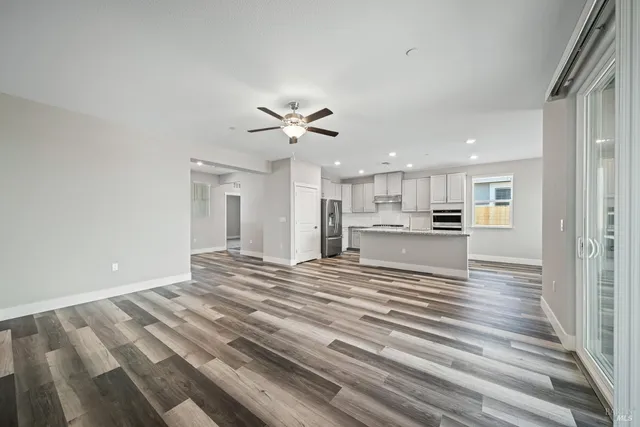 a view of kitchen with kitchen island refrigerator stove and wooden floor