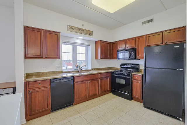 a kitchen with stainless steel appliances granite countertop a refrigerator stove top oven a sink and dishwasher