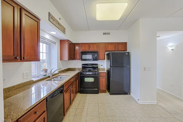 a kitchen with stainless steel appliances granite countertop a refrigerator and a sink