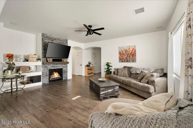 a living room with furniture a fireplace and a flat screen tv