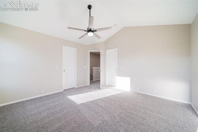 9356 Bethpage Road Peyton, CO 80831 - Photo 21 of 40 Unfurnished bedroom featuring ceiling fan, light colored carpet, and vaulted ceiling