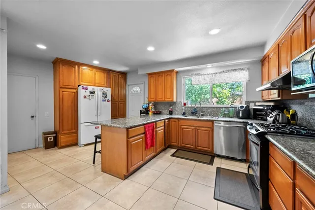 a kitchen with stainless steel appliances granite countertop a refrigerator and a stove