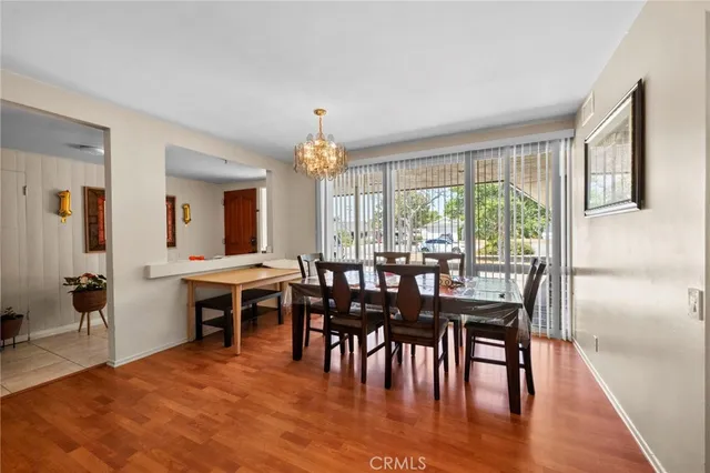 a view of a a dining room with furniture window and wooden floor