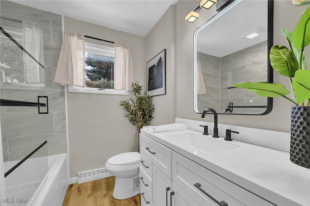1731 Berger Road Akron, OH 44312 - Photo 19 of 37 Bathroom with vanity, light wood finished floors, shower combination, and baseboard heating
