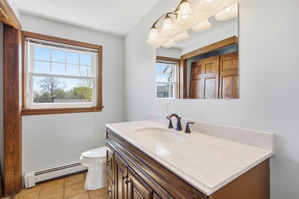 50 Harborview Road Hull, MA 02045 - Photo 23 of 41 a bathroom with a sink a mirror and a toilet