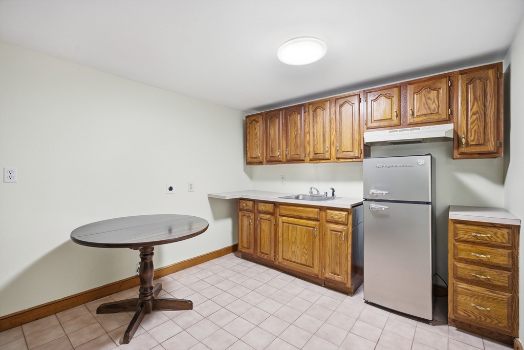 50 Harborview Road Hull, MA 02045 - Photo 24 of 41 a kitchen with stainless steel appliances granite countertop a refrigerator sink and cabinets