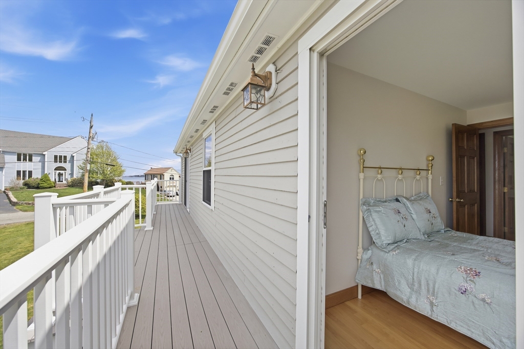 50 Harborview Road Hull, MA 02045 - Photo 6 of 41 a bedroom with a bed and a large window with wooden floor