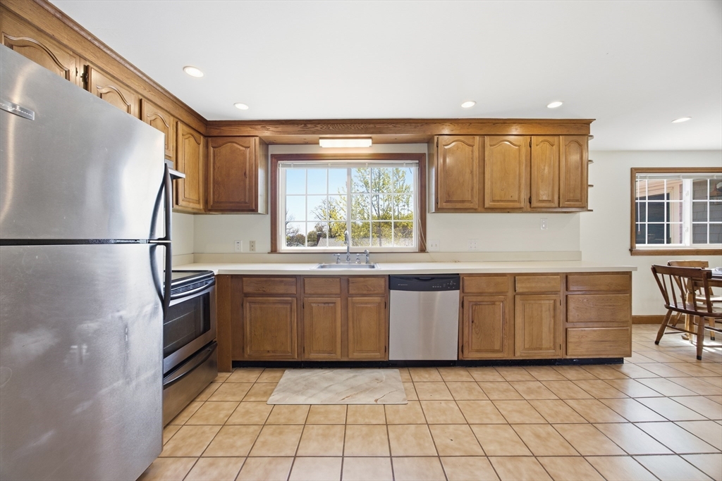 50 Harborview Road Hull, MA 02045 - Photo 8 of 41 a kitchen with white cabinets a window and stainless steel appliances