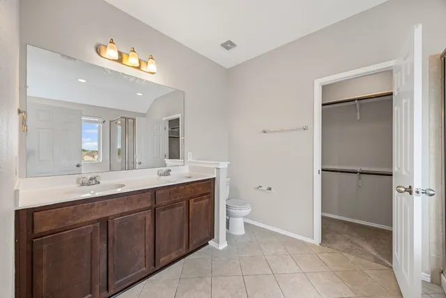 a spacious bathroom with a double vanity sink a mirror and a bathtub