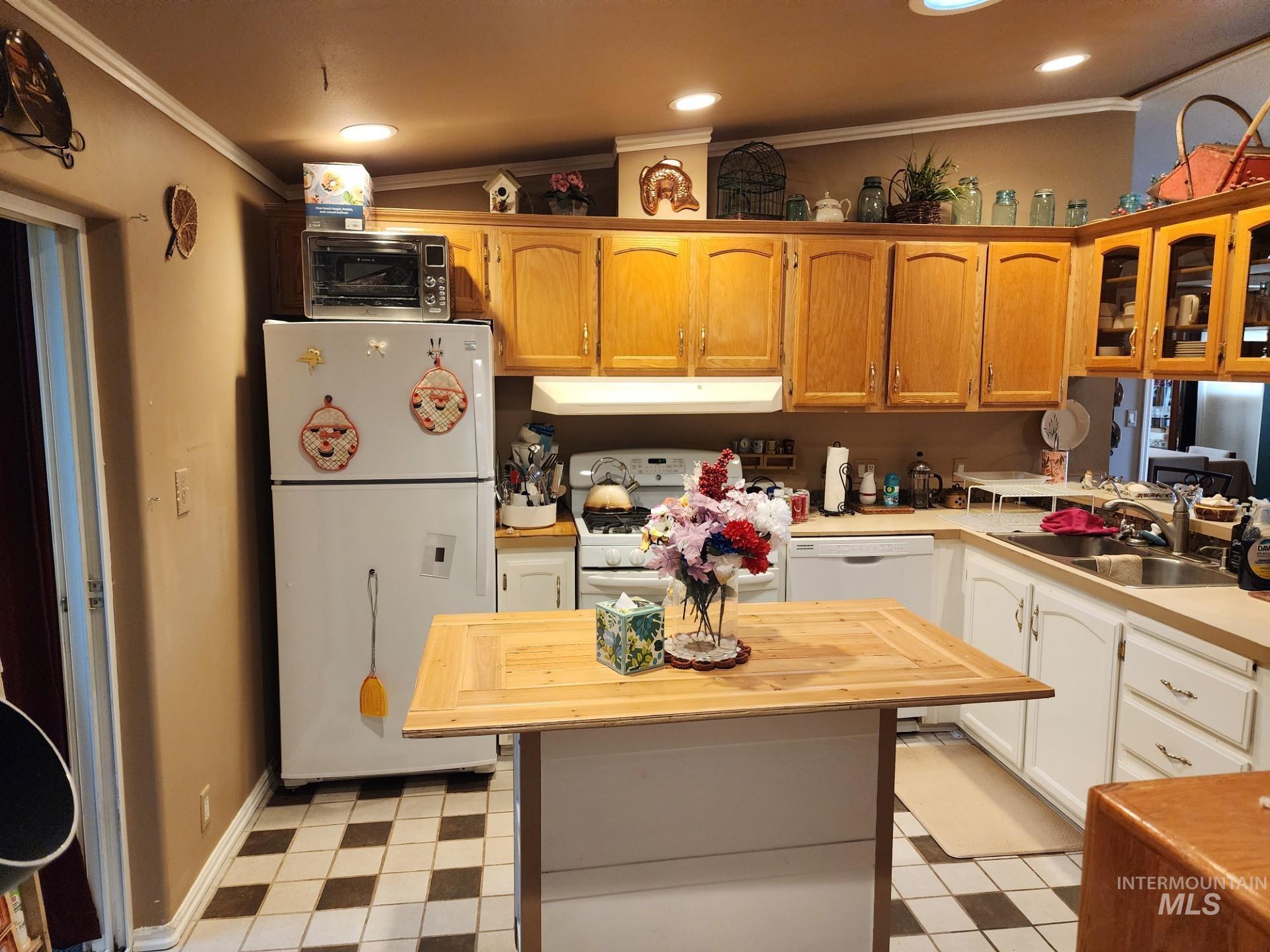 235 5th Street Grand View, ID 83624 - Photo 8 of 22 Kitchen featuring wood cabinetry, white appliances, a light-colored countertop, and a checkerboard floor pattern