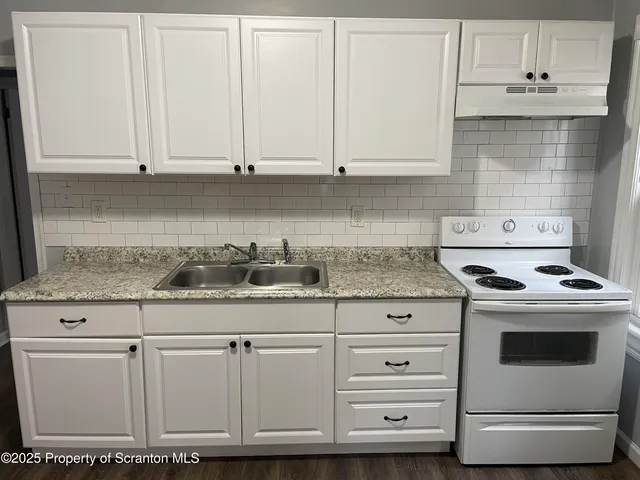 a kitchen with granite countertop white cabinets and white appliances