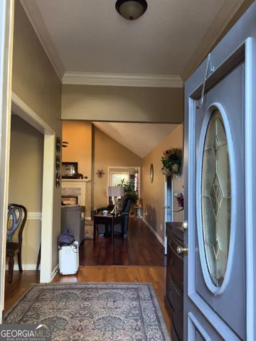a living room with furniture a rug and kitchen view