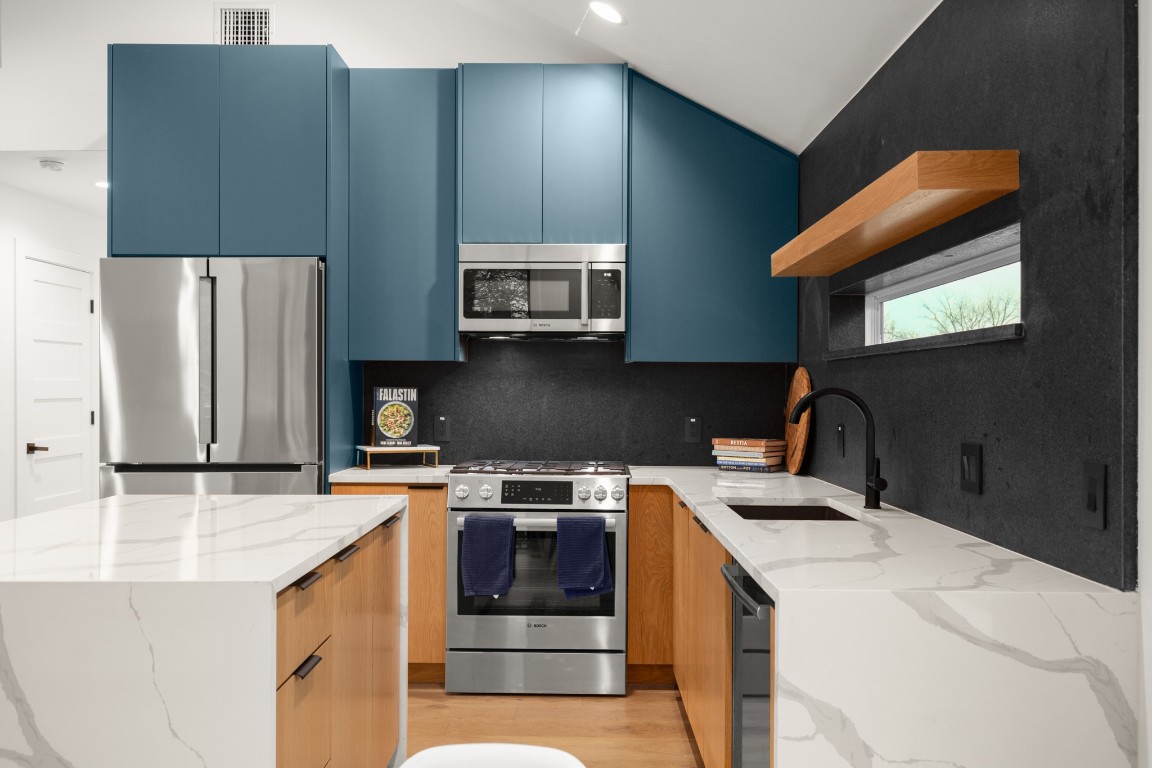 a kitchen with stainless steel appliances a stove a sink and a microwave