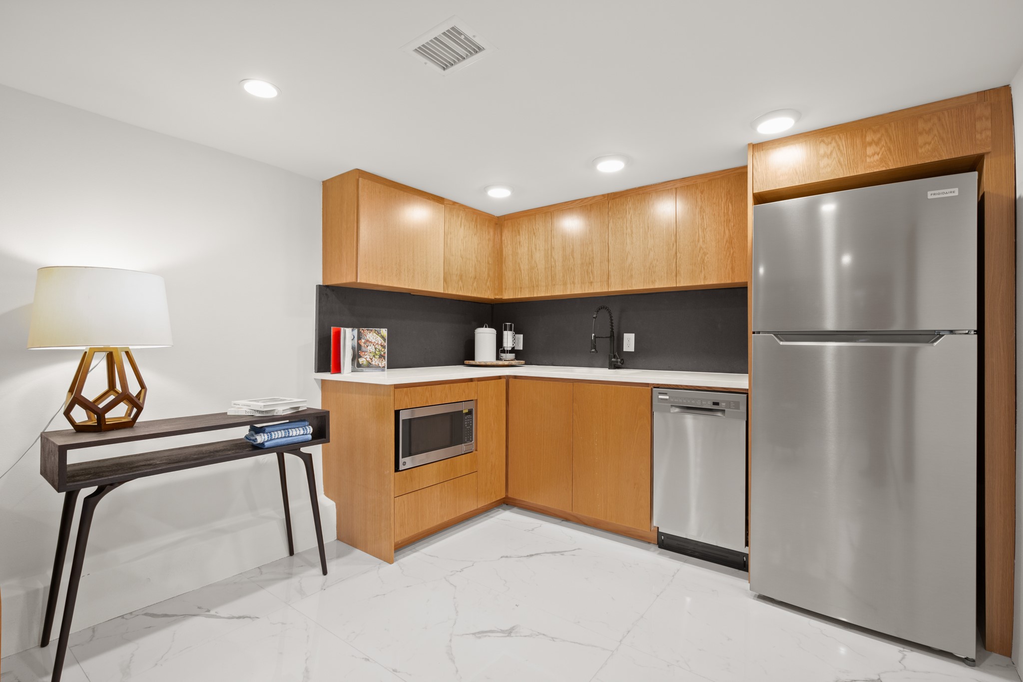 2416 East 10th Street Austin, TX 78702 - Photo 26 of 38 a kitchen with white cabinets and stainless steel appliances