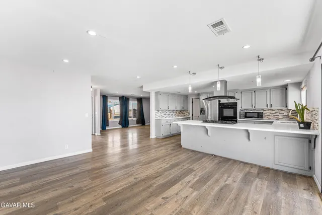 a large white kitchen with lots of counter space a sink and appliances