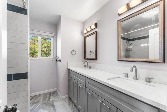 a bathroom with a double vanity sink and a mirror