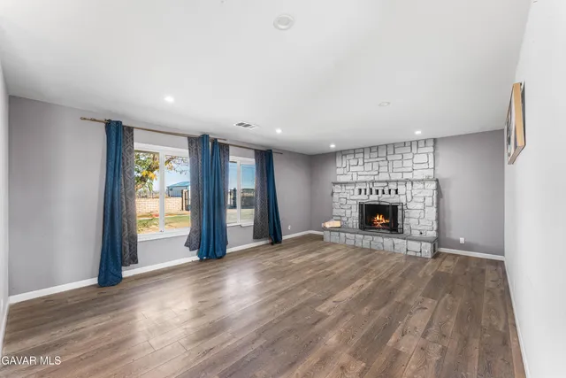 a view of an empty room with a fireplace and a window