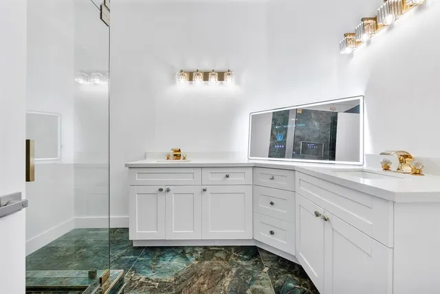 a kitchen with white cabinets and sink