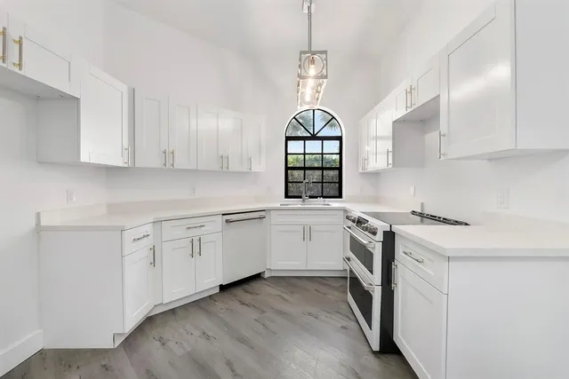 a kitchen with granite countertop white cabinets and white appliances