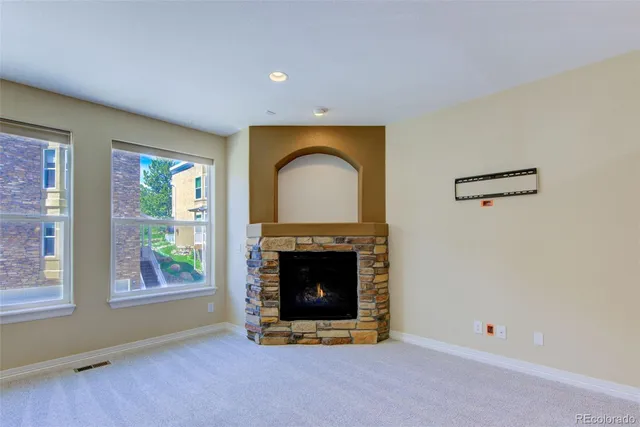 a view of an empty room with a fireplace and a window
