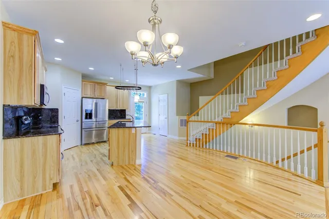 a view of a living room with wooden floor and a chandelier