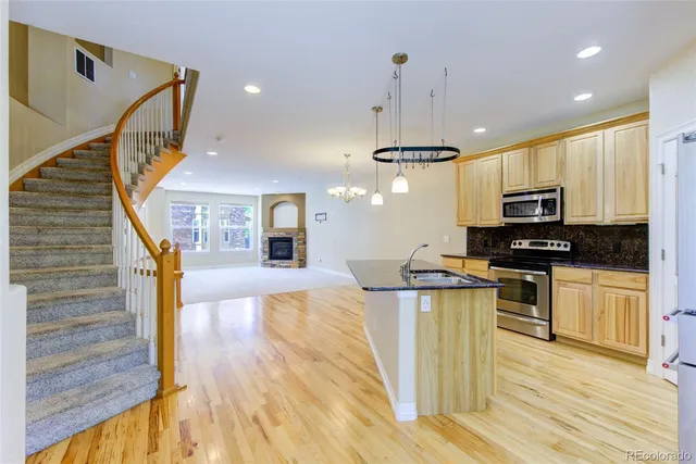 a kitchen with granite countertop a stove a sink and a microwave