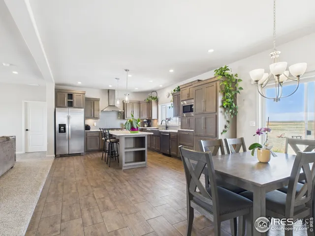 a kitchen with a dining table chairs and refrigerator