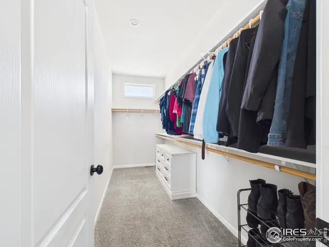 a view of walk in closet with clothes