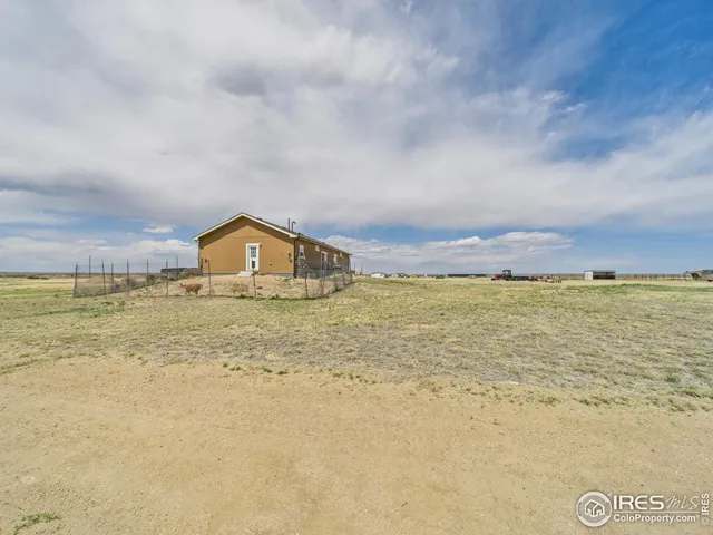 a view of pool with lawn chairs and wooden fence