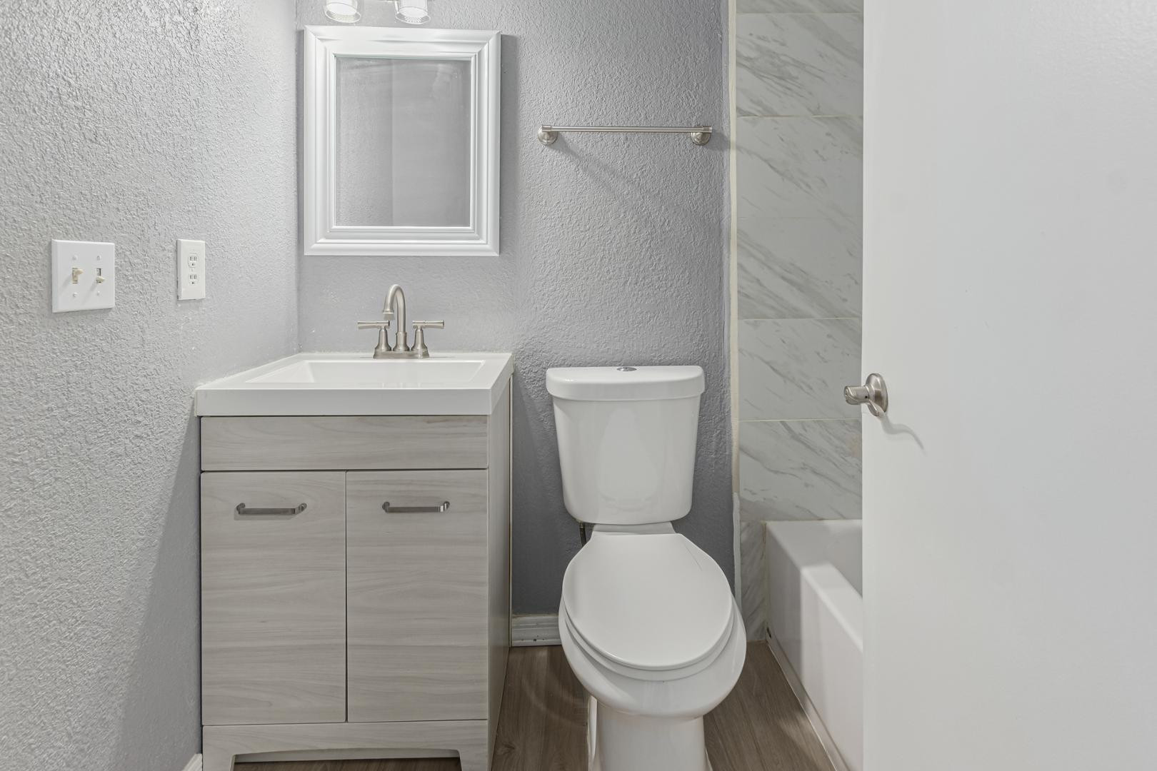 1077 West 1st Street, Unit 203 Tempe, AZ 85281 - Photo 13 of 22 a bathroom with a toilet sink vanity and mirror