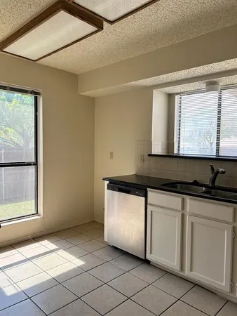 a kitchen with granite countertop white cabinets and sink