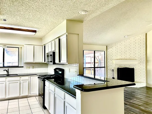 a kitchen with granite countertop a stove sink and cabinets