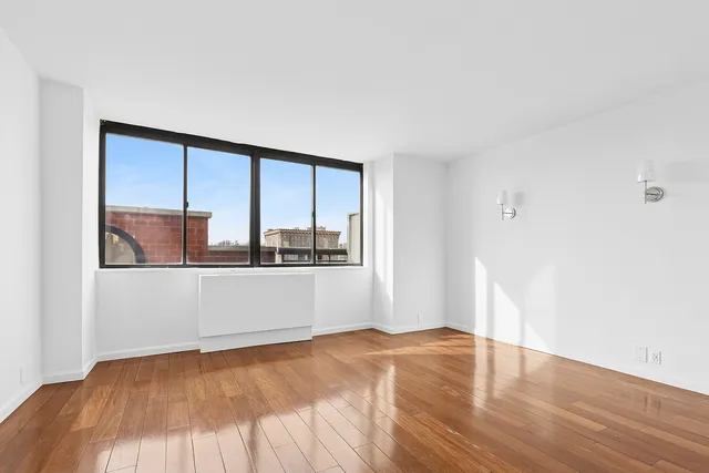 a bedroom with a bed and a large window with outer view
