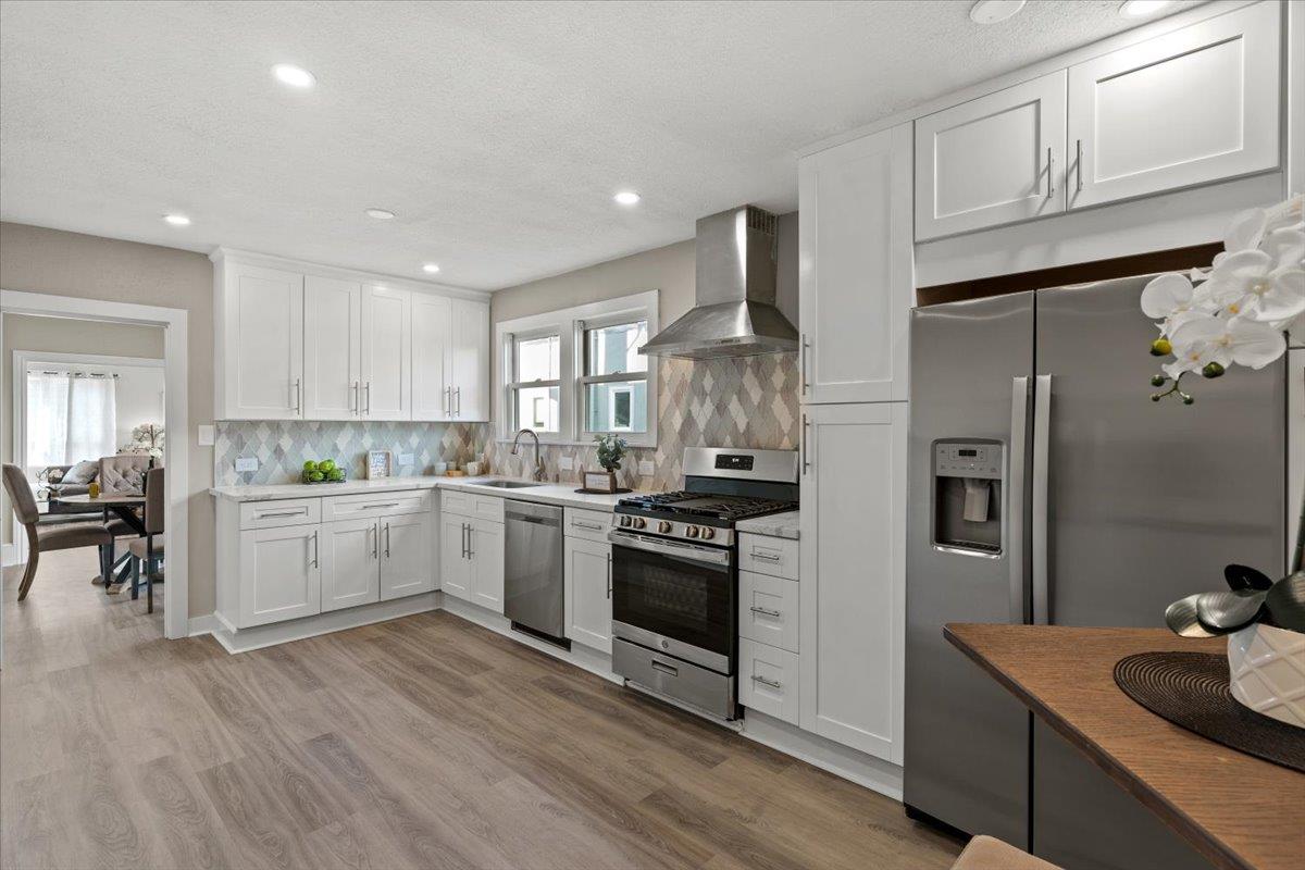 1306 Channing Way Berkeley, CA 94702 - Photo 10 of 42 a kitchen with stainless steel appliances white cabinets a sink a stove a refrigerator and wooden floor