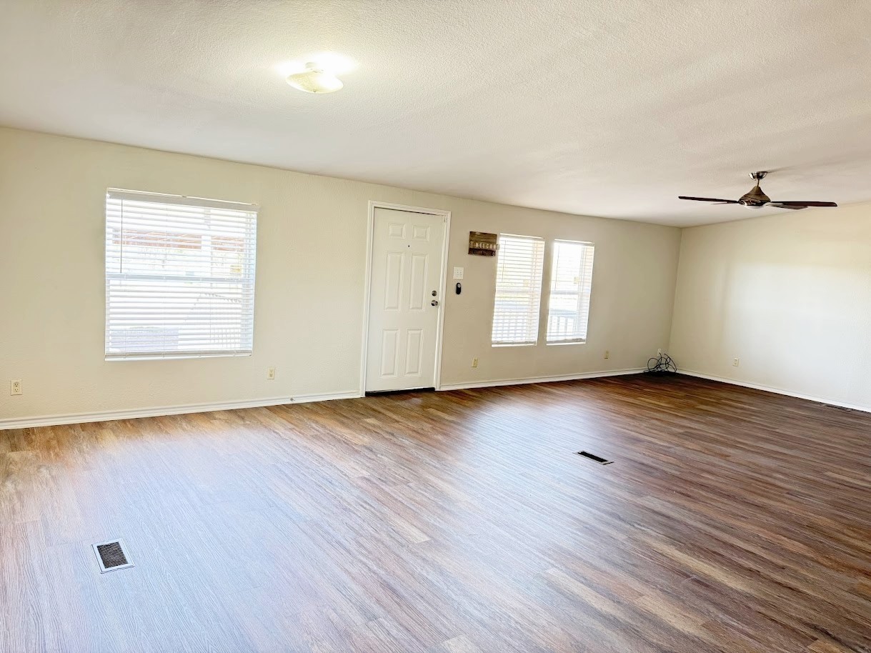 2709 County Road 463 Elgin, TX 78621 - Photo 11 of 25 an empty room with wooden floor and windows