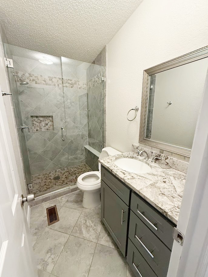 2709 County Road 463 Elgin, TX 78621 - Photo 16 of 25 a bathroom with a granite countertop sink a toilet and a shower