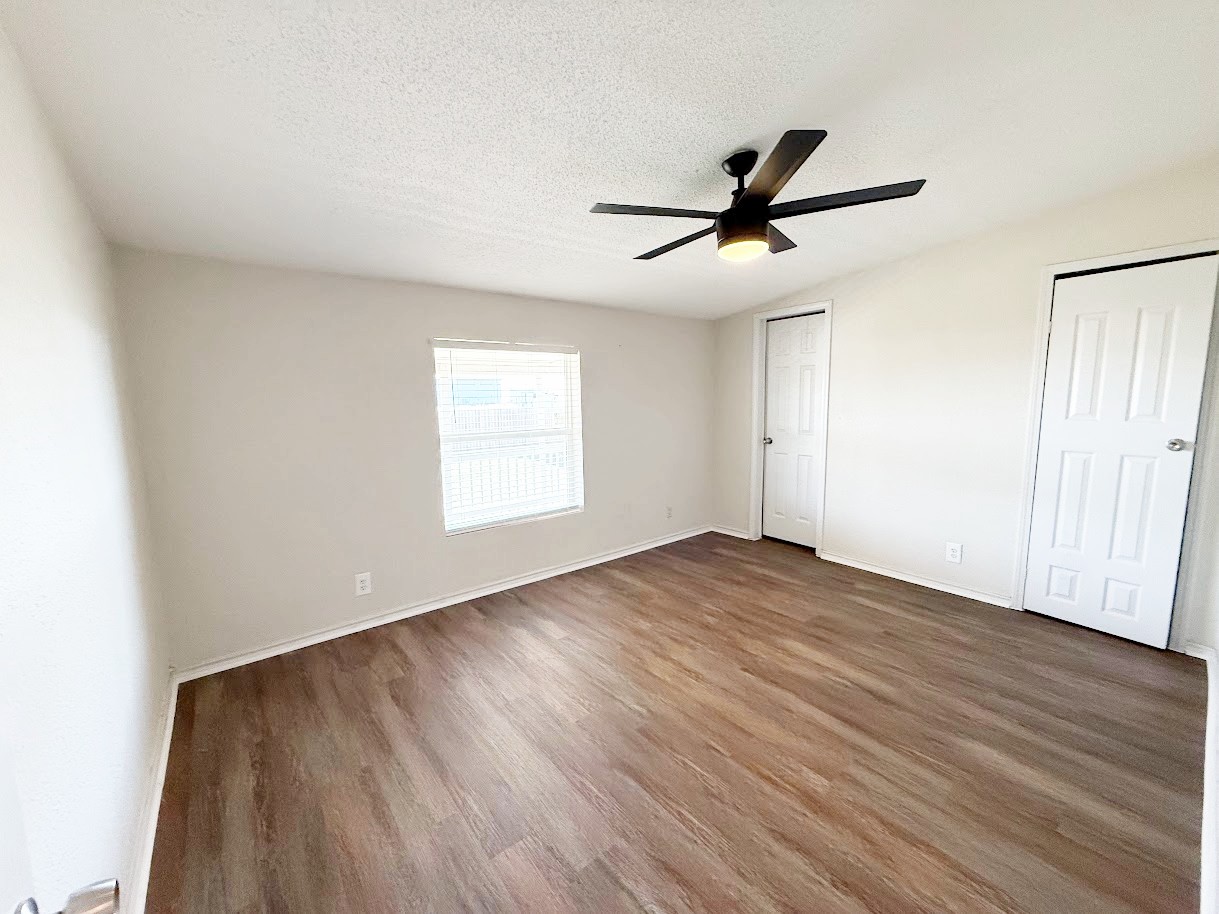 2709 County Road 463 Elgin, TX 78621 - Photo 20 of 25 an empty room with wooden floor fan and windows