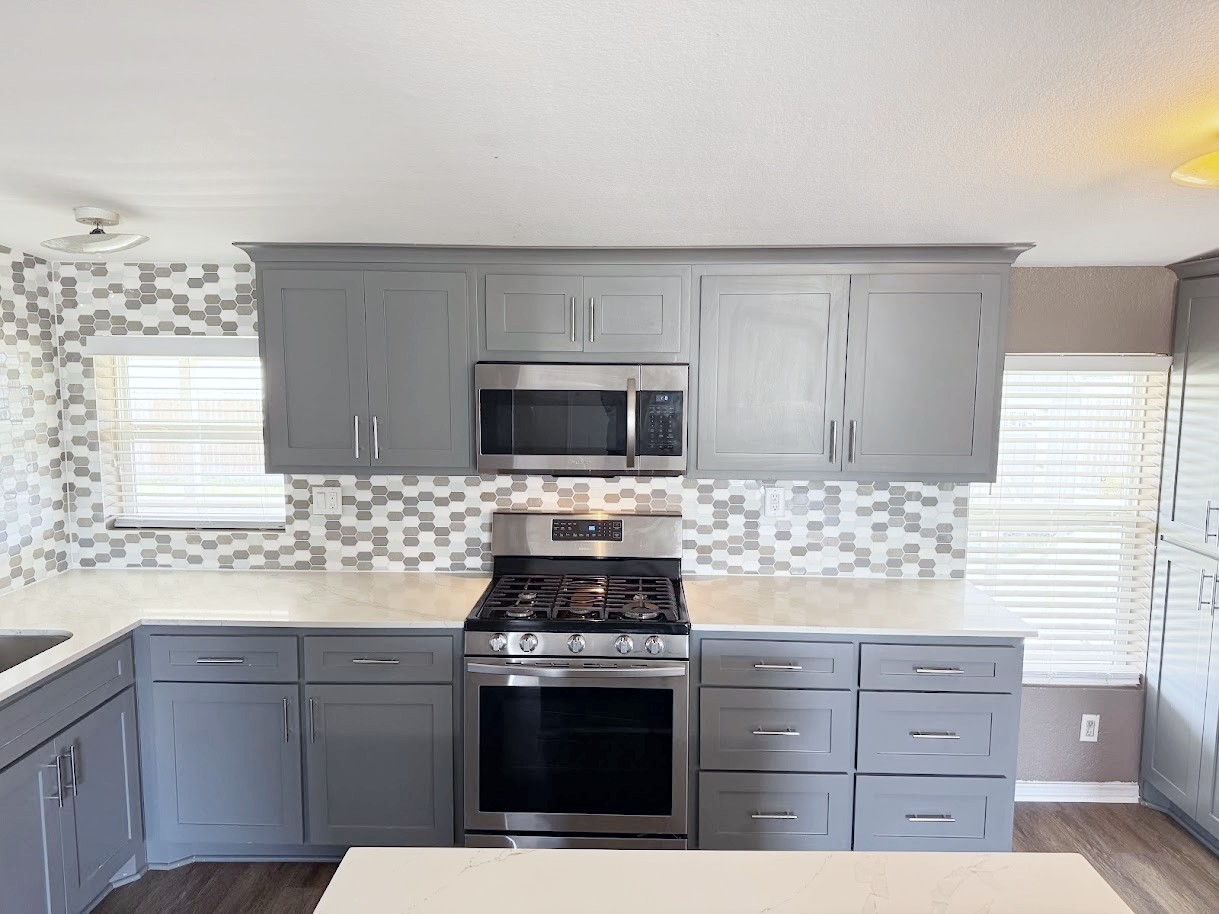 2709 County Road 463 Elgin, TX 78621 - Photo 6 of 25 a kitchen with stainless steel appliances kitchen island granite countertop a stove a sink and a microwave