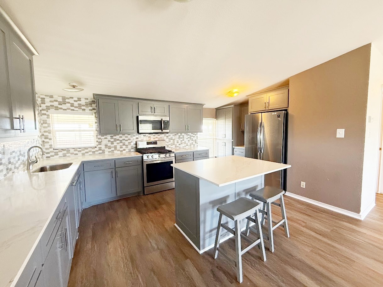 2709 County Road 463 Elgin, TX 78621 - Photo 7 of 25 a kitchen with a table chairs refrigerator and cabinets