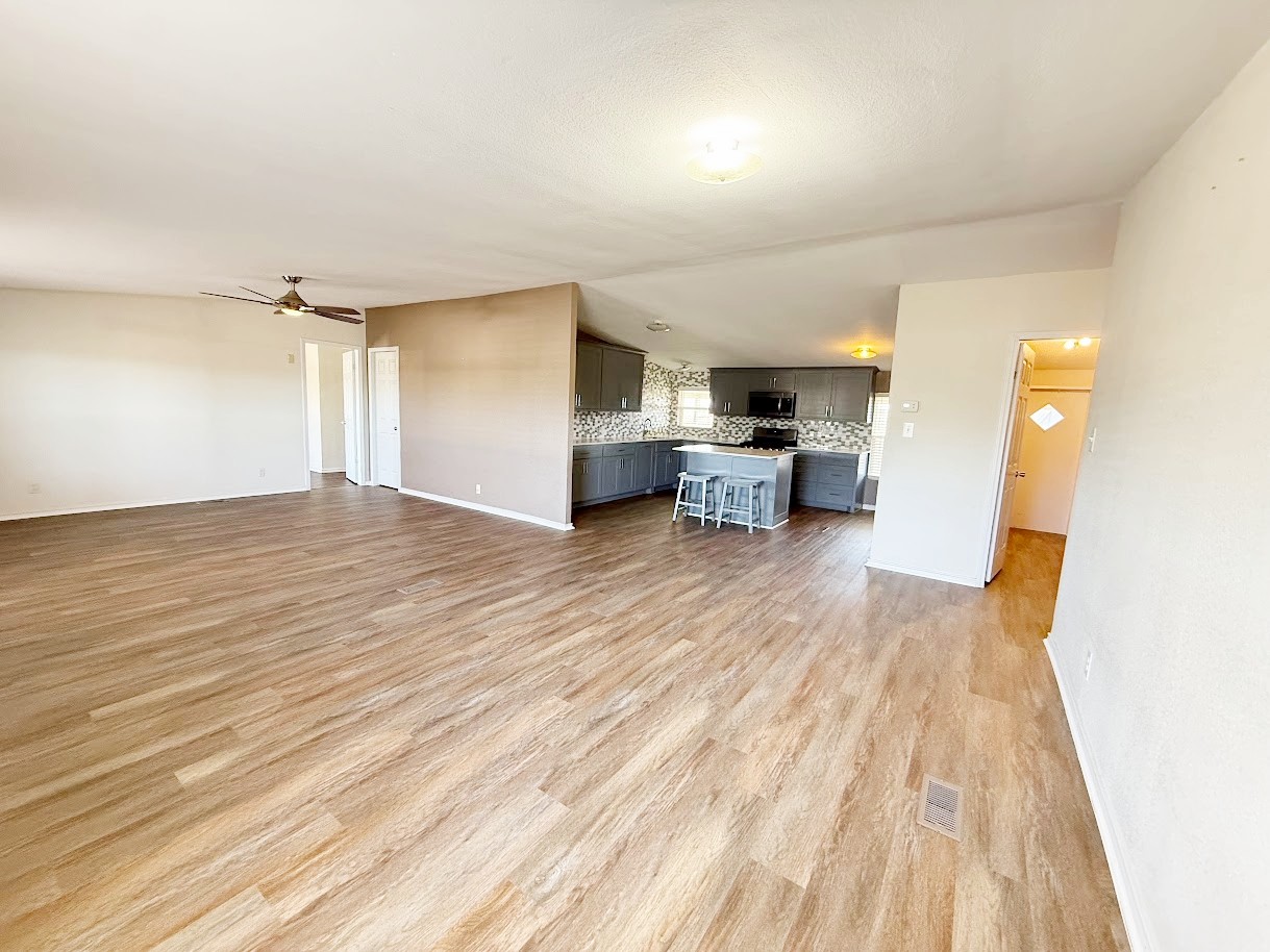 2709 County Road 463 Elgin, TX 78621 - Photo 8 of 25 a view of a living room a kitchen and a wooden floor