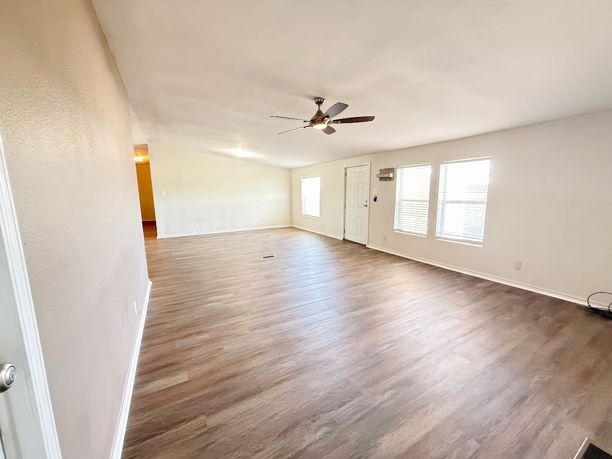 2709 County Road 463 Elgin, TX 78621 - Photo 10 of 25 an empty room with wooden floor and ceiling fan