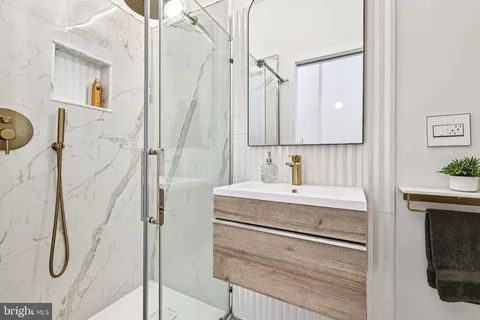 a bathroom with a granite countertop sink a vanity and shower